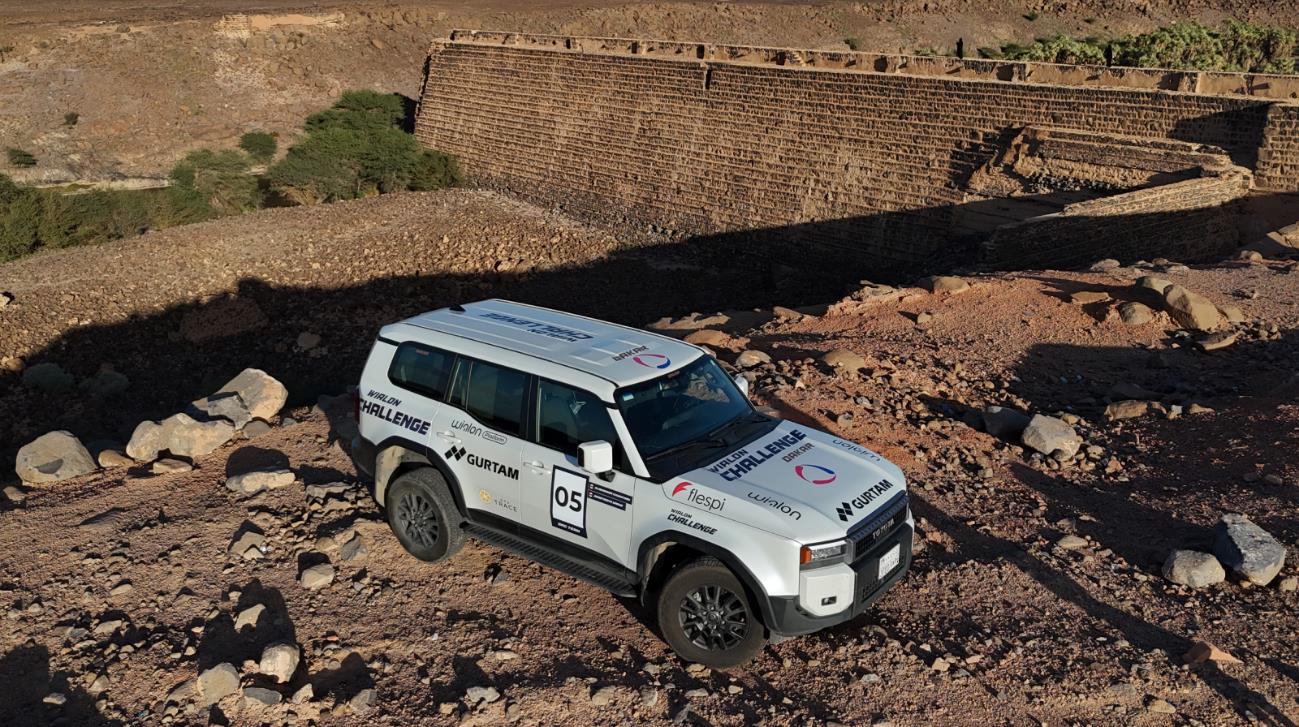 Toyota Land Cruiser Prado branco superando terreno rochoso no deserto